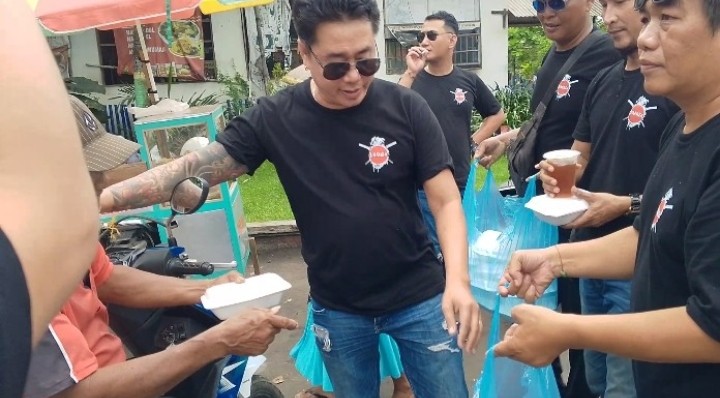 Foto: Ketua Yakuza Farm Pati, Aris Sutiyono yang akrab disapa Nyaksu membagikan makanan di depan pintu masuk Terminal Pati.(Portalljateng/Adm)