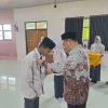Foto: Kepala MTsN 1 Pati, Wahyu Hidayat kalungkan secara simbolis tanda peserta Latihan Dasar Kepemimpinan Siswa (LDKS) tahun 2025.(Portalljateng/MTsN 1 Pati)